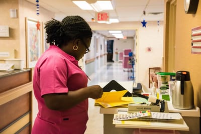 Staff member organizing documents in a facility hallway