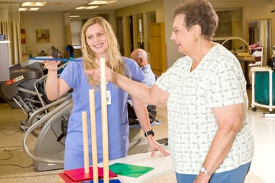 Staff assisting a resident with an activity in a common area
