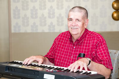 Resident playing keyboard in a welcoming lounge