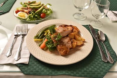 Plated meal with chicken, vegetables, and salad