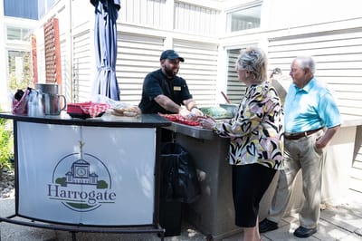 Staff member serving food to residents outdoors