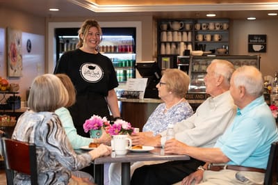 Staff member interacting with residents in a café
