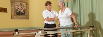 Staff assisting a resident with therapy exercise