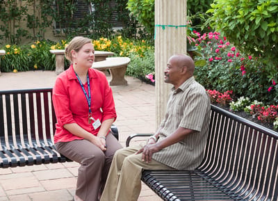 A staff member talking with a resident in a garden
