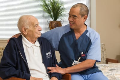 Caregiver interacting with elderly resident in a cozy room