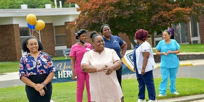 Staff and residents celebrating outdoors with balloons