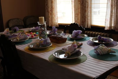 Decorated dining table with festive napkins and food.