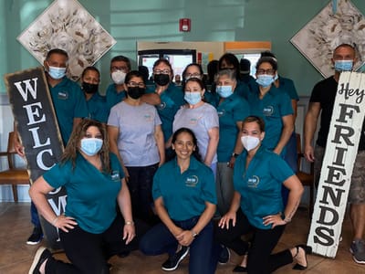 Staff and residents posing together in a cheerful common area