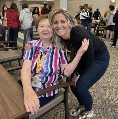 Resident and staff member posing in a common area