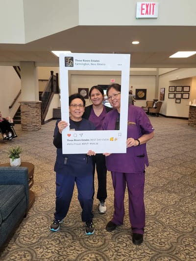 Staff celebrating in the common area with a photo frame