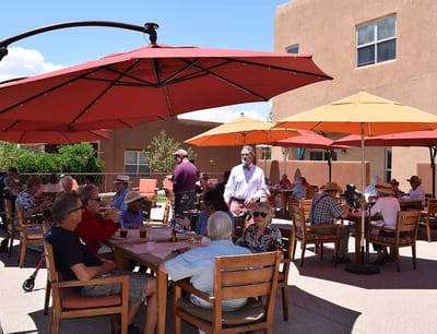 Residents enjoying lunch under outdoor umbrellas