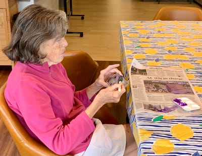Resident engaged in a craft activity at a table