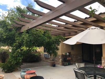 Outdoor pergola with plants and seating area