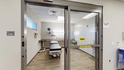 Private resident room with a hospital bed and caution sign