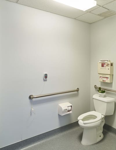 A simple restroom with a toilet and grab bars