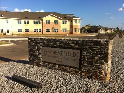 Stone sign displaying Wheatfields Senior Living Community name
