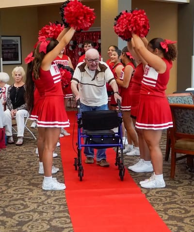 Residents celebrating with cheerleaders at a lively event