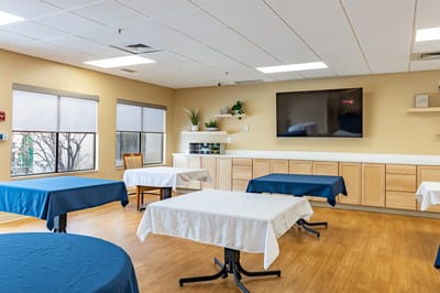Bright activity room with tables and a television