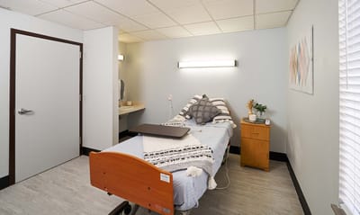 Private room with a bed and bedside table