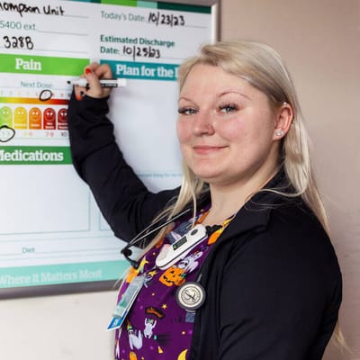 Staff member updating patient discharge information on a board