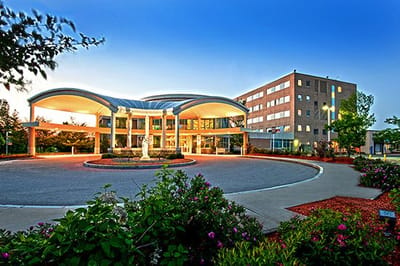 Exterior view of St. Joseph Hospital entrance surrounded by greenery