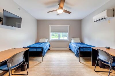 Private resident room with two beds and desks