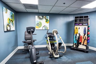 Fitness room with exercise equipment and colorful artwork