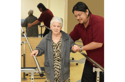 Staff assisting a resident with rehabilitation