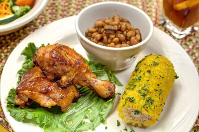 Plate of roasted chicken, corn, and baked beans