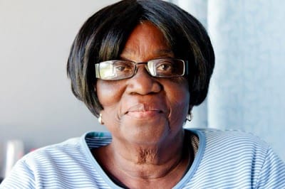 A smiling resident with glasses indoors