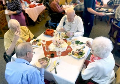 Residents enjoying a meal together in the dining room
