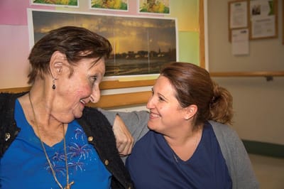 A resident and staff member sharing a moment in a common area