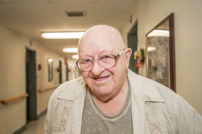 Resident smiling in a hallway of the facility