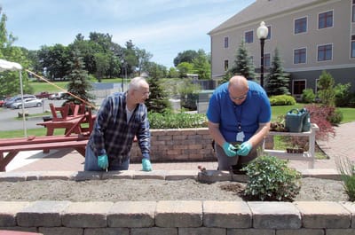 Residents and staff gardening in outdoor space