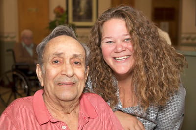 Resident and staff member smiling together in a common area
