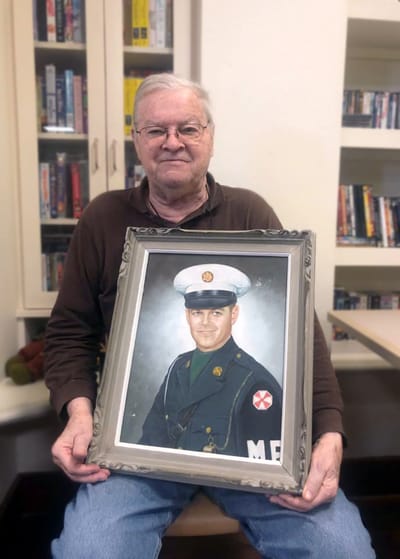 Resident holding a framed portrait in a common area