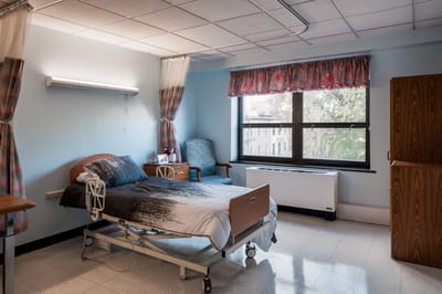 A well-furnished resident room with large window