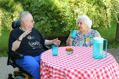 Two residents enjoying drinks at an outdoor table