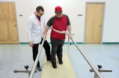 A resident practicing walking with staff assistance