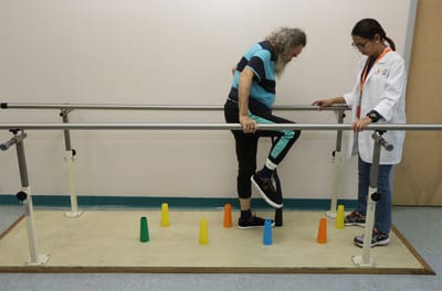A resident practicing walking assistance with a therapist