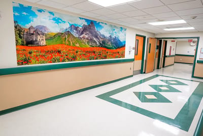 Brightly lit hallway with scenic mural and polished floor