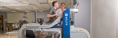Therapist assisting a resident on an anti-gravity treadmill
