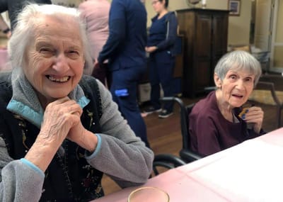 Two smiling residents enjoying time together indoors