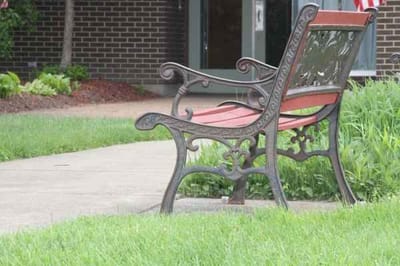 Outdoor bench in a grassy area of a senior facility