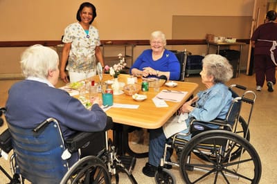 Residents enjoying a meal in the dining area with staff