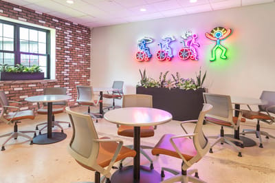 Bright common area with seating and neon artwork