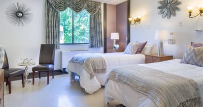 A cozy resident room with two beds and natural light