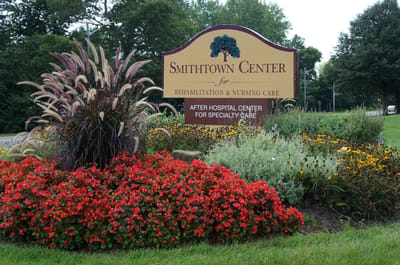 Entrance sign of Smithtown Center with colorful flowers