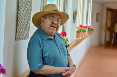 Elderly man smiling in a colorful hallway