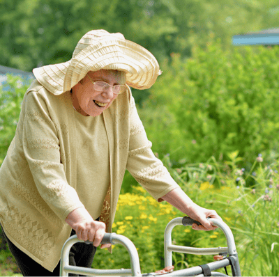 Elderly woman enjoying the garden with a walker
